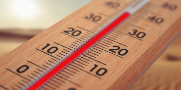 Thermometer reaching 40 degrees celsius against background of scorching sun