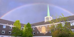 A rainbow over Rutland, a catered student hall. The top of the spire appears to be touching the rainbow.