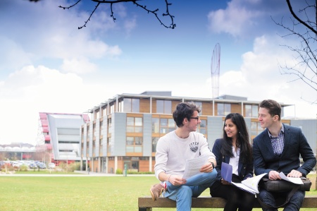Three postgraduate students studying in front of Business School North, Jubilee campus